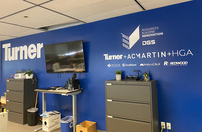 Blue wall in a office with company logos on it